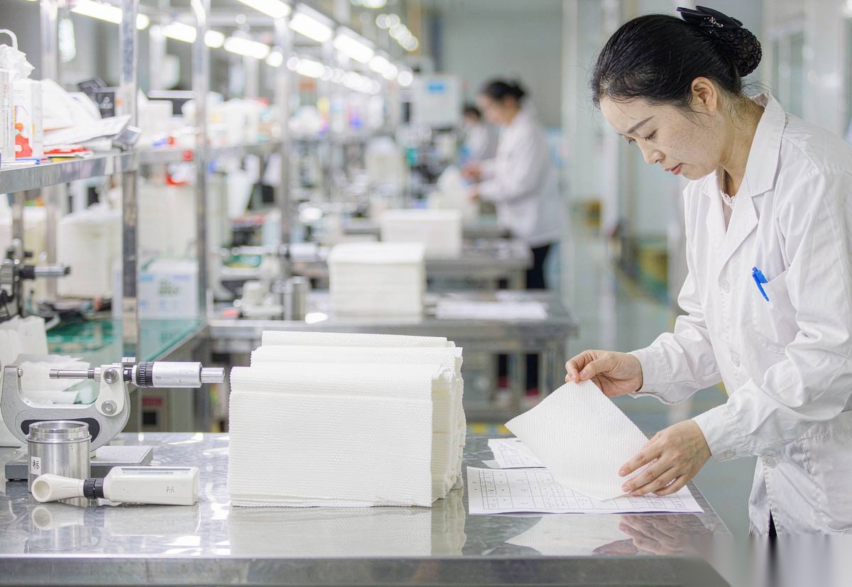 Factory quality control inspector checking napkins against spec sheet